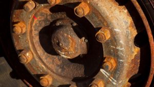 Rusty sandblasting wheels with worn-out bolts and a corroded surface.