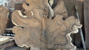 Large natural wood slabs with rich grain patterns displayed in a workshop after cleaning and refinishing, perfect example of restoration done through wood sandblasting near me services.